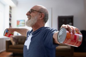 Man exercising using tins of food as weights