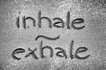 Inhale, exhale words written in sand